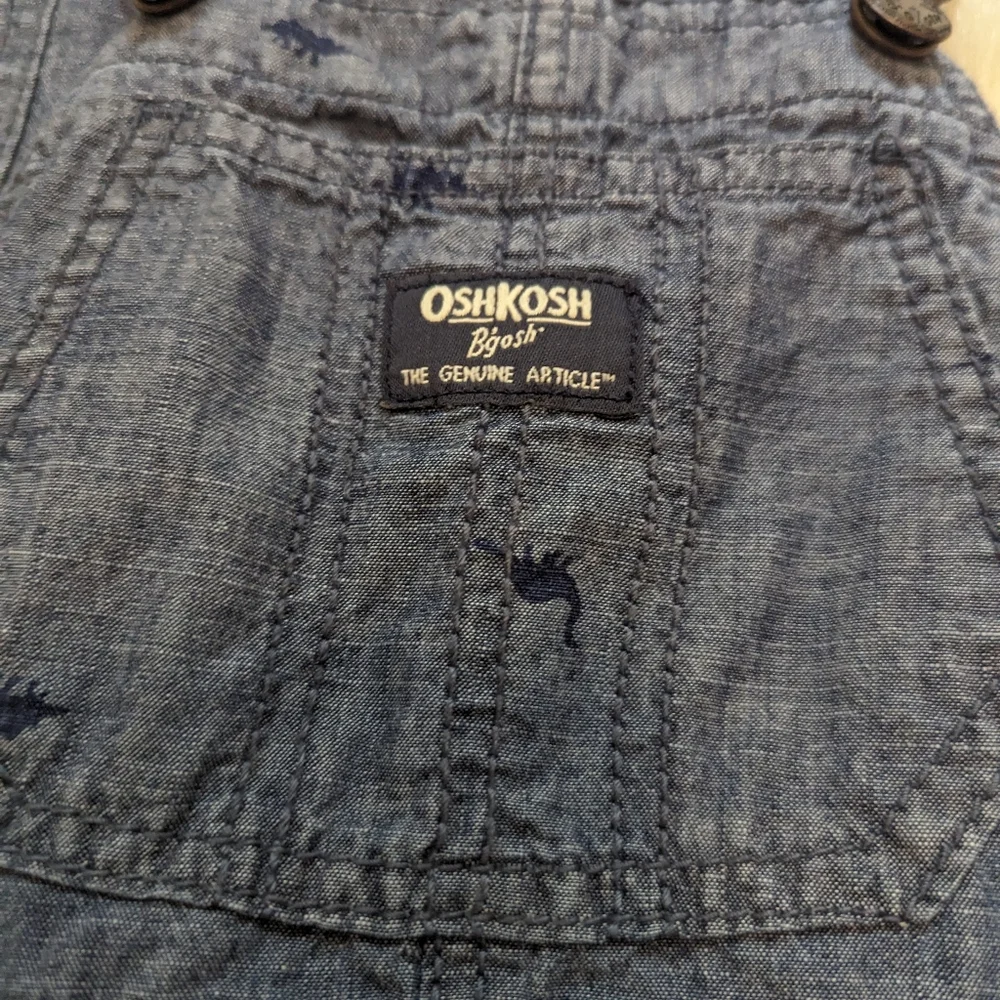 Oshkosh B'gosh blue overalls with navy blue dinosaur print size 2T